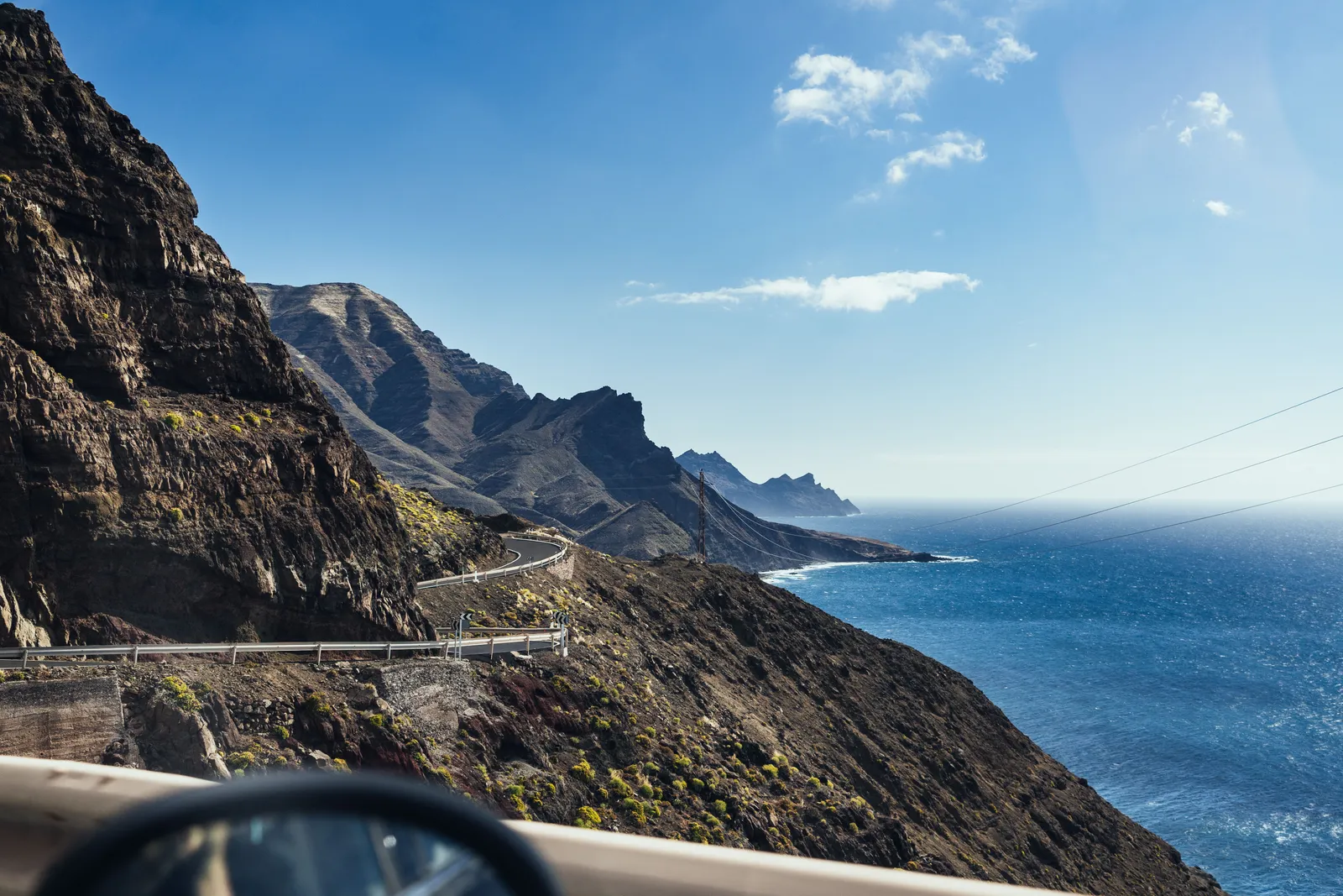 Una strada di montagna sopra il mare, vista attraverso il parabrezza