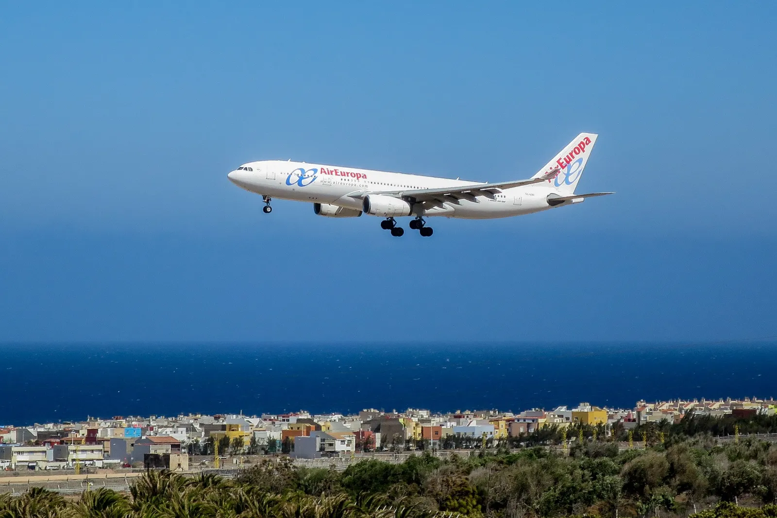 Un aereo di linea in atterraggio sopra la costa